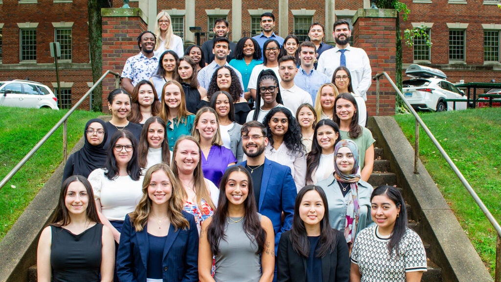 A group of students and faculty from the Physiology program pose on the Med-Dent Steps during Fall 2024 Orientation.