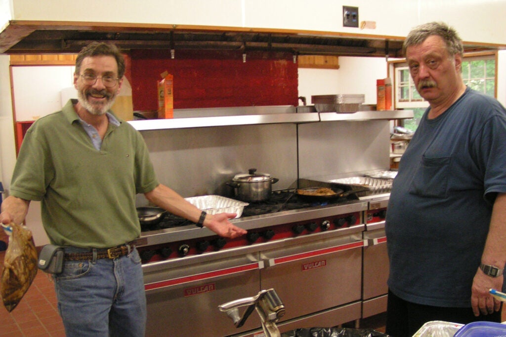 Pharmacology professors Barry Wolfe and Jarda Wroblewski stand in a kitchen during a department retreat.