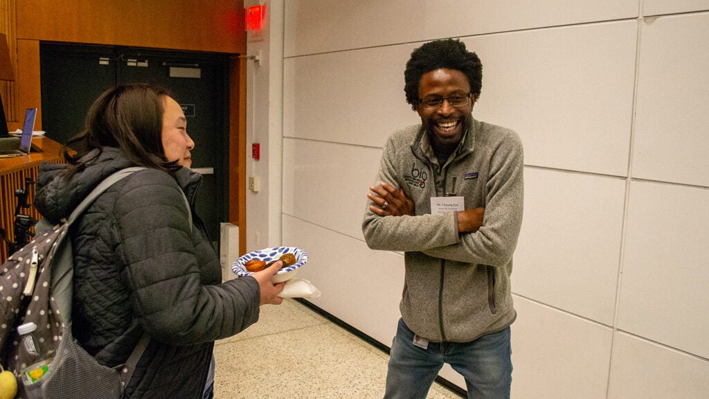 Ukpong Eyo (right), a microglia researcher at the University of Virginia, speaks with a student after giving the keynote presentation.