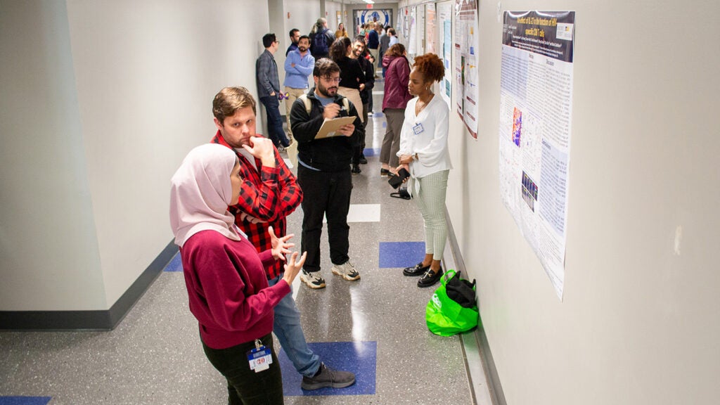 Attendees discuss research during the Student Research Day 2024 poster session.