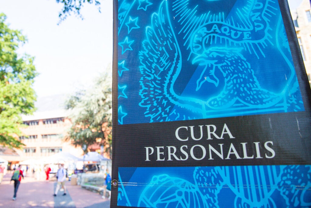 A banner with the Georgetown seal and "Cura Personalis" with a campus space in the background