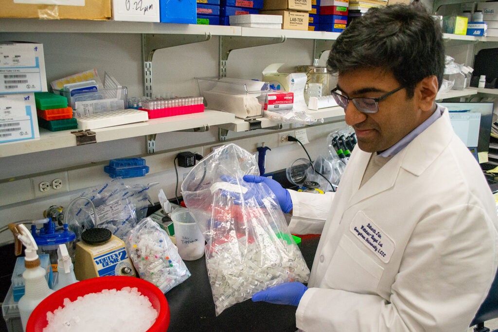 Tumor Biology M.D./Ph.D. student Sidharth Jain holds a bag of sample tubes in the Wellstein-Riegel Lab