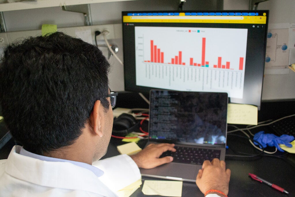 Tumor Biology M.D./Ph.D. student Sidharth Jain views data and code on a computer in the Wellstein-Riegel Lab