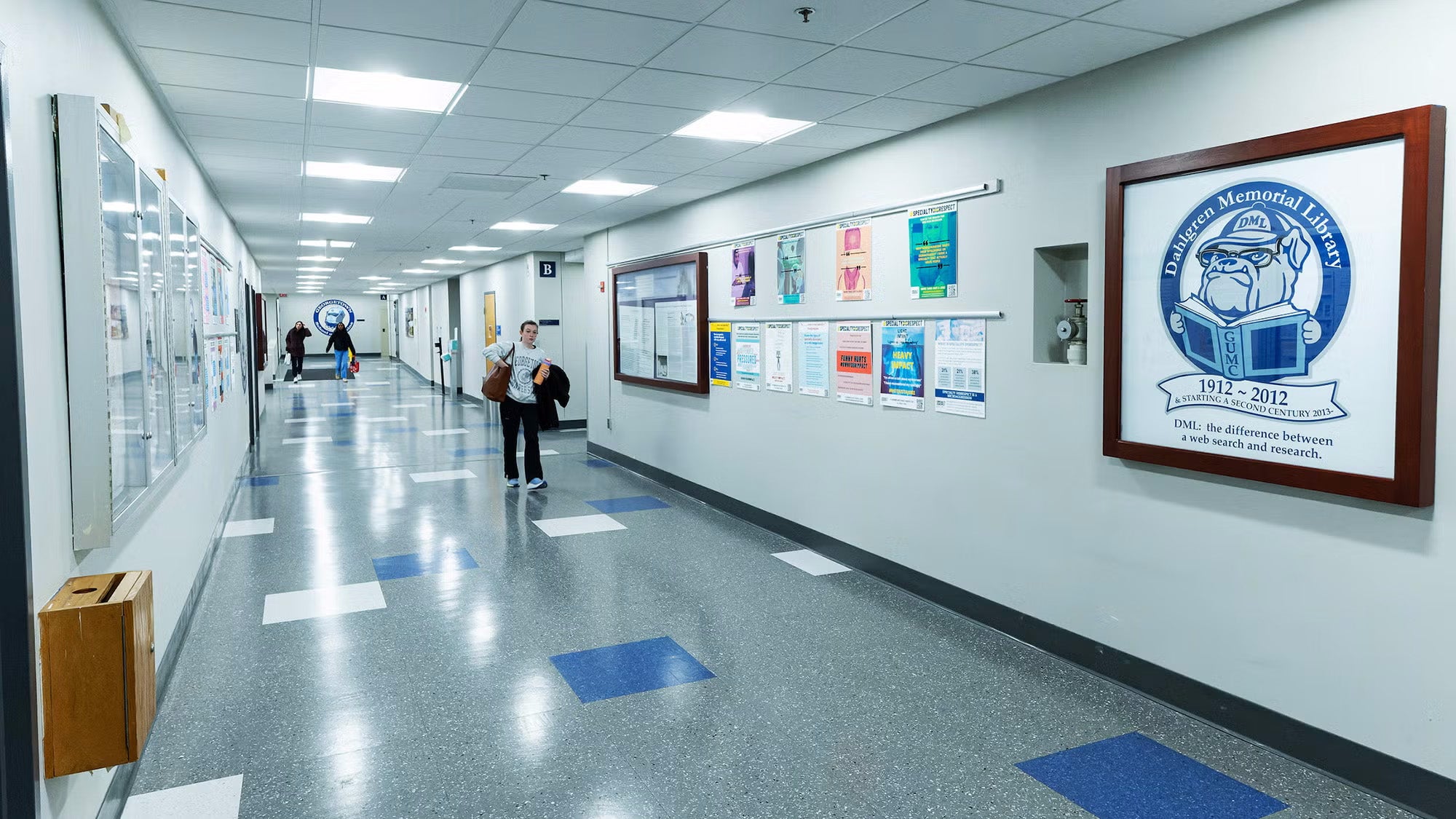 A student walks down a brightly lit hallway in the Pre-Clinical Science Building