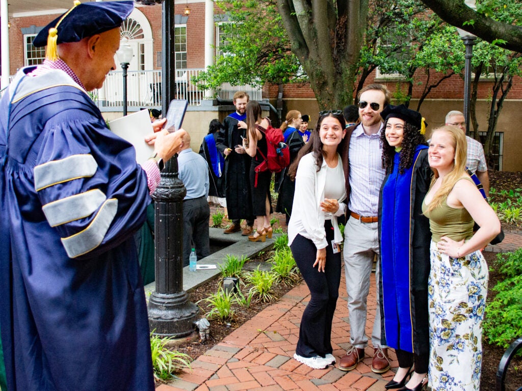 Ph.D. graduate poses for a photo at the Doctoral Hooding Reception