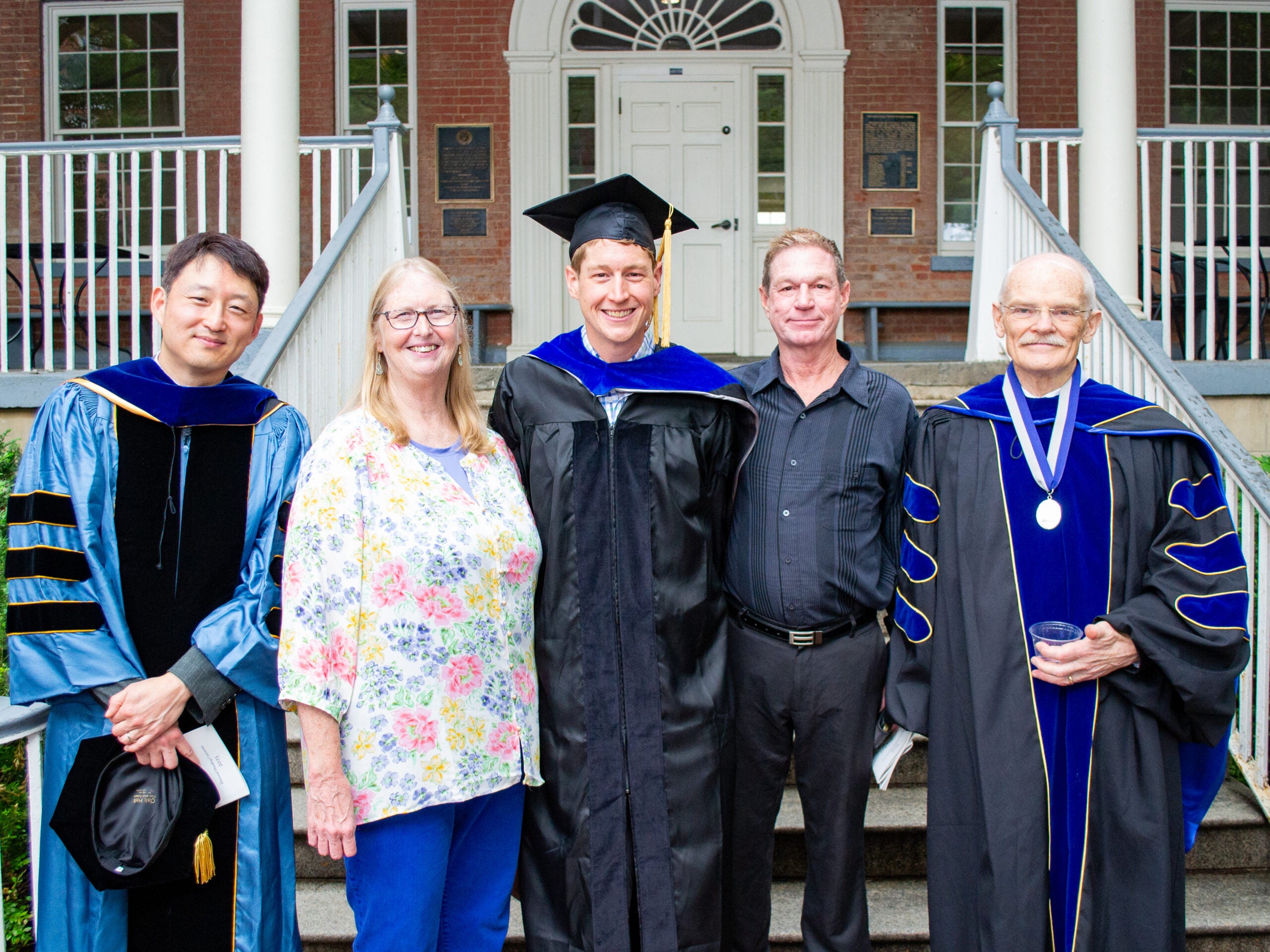 Ph.D. graduate, family and faculty at the Doctoral Hooding Reception