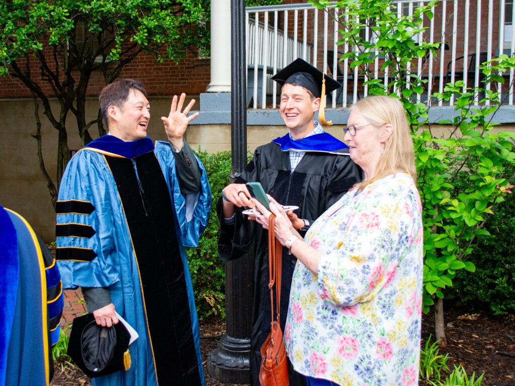Ph.D. graduate, family and faculty at the Doctoral Hooding Reception