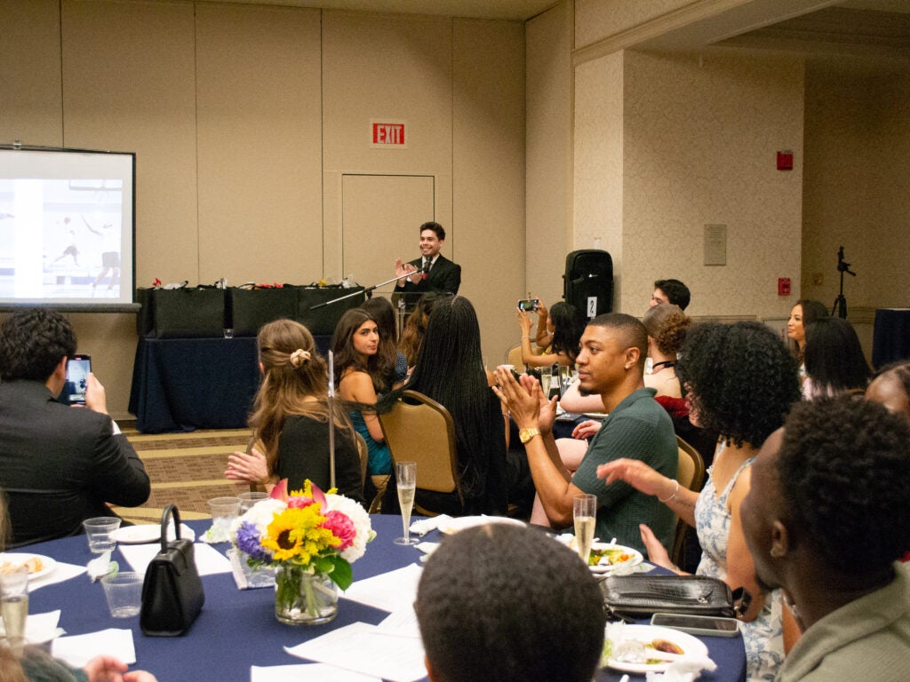 Students listening to a student speaker at the Integrative Medicine & Health Sciences program gala