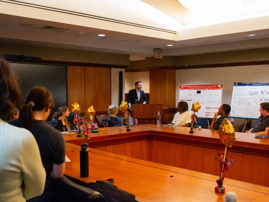 A student addresses attendees at the Department of Neuroscience poster session