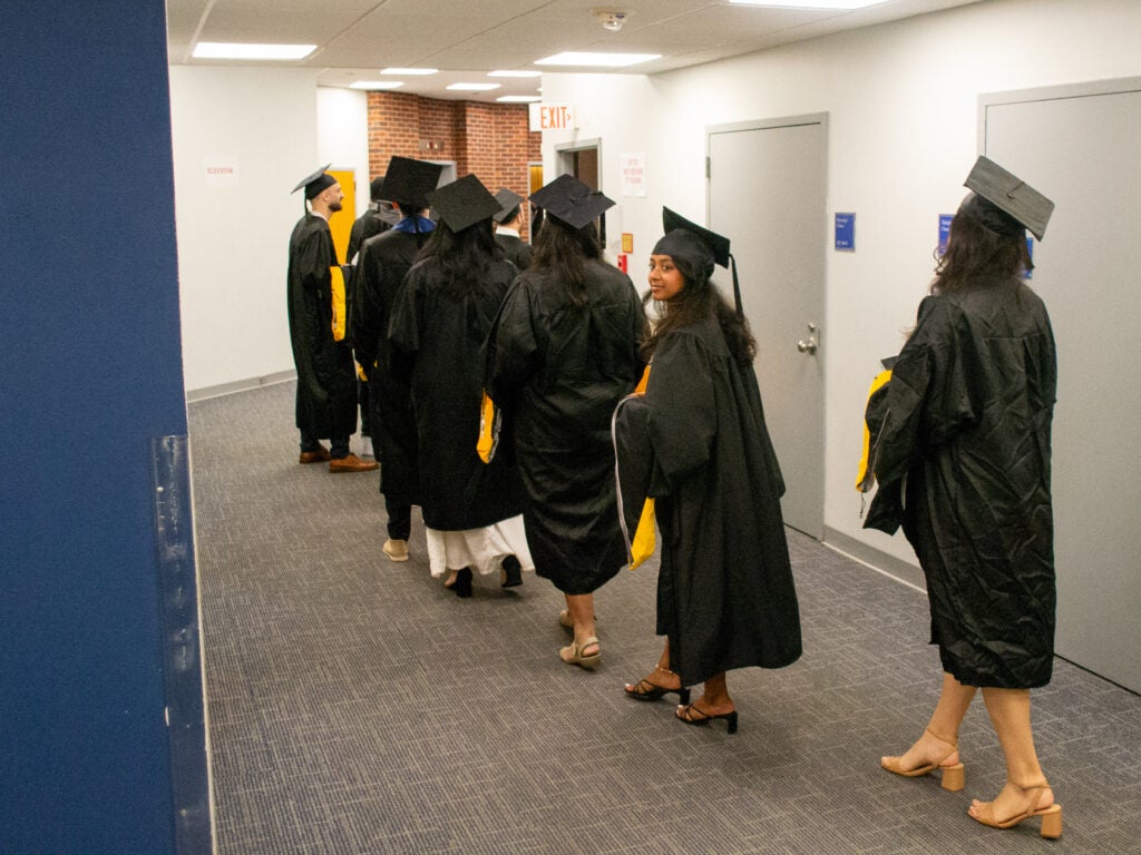 Graduates walk through the Intercultural Center at Commencement line-up