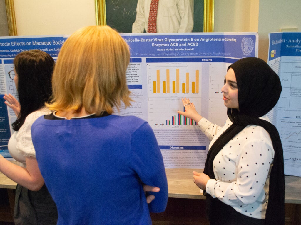 A student presents her research at the Pharmacology and Physiology poster session