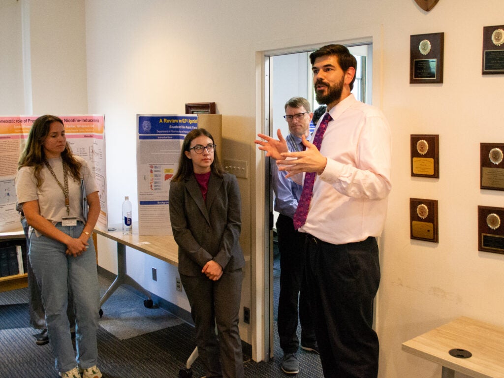 Faculty address attendees at the Pharmacology and Physiology poster session