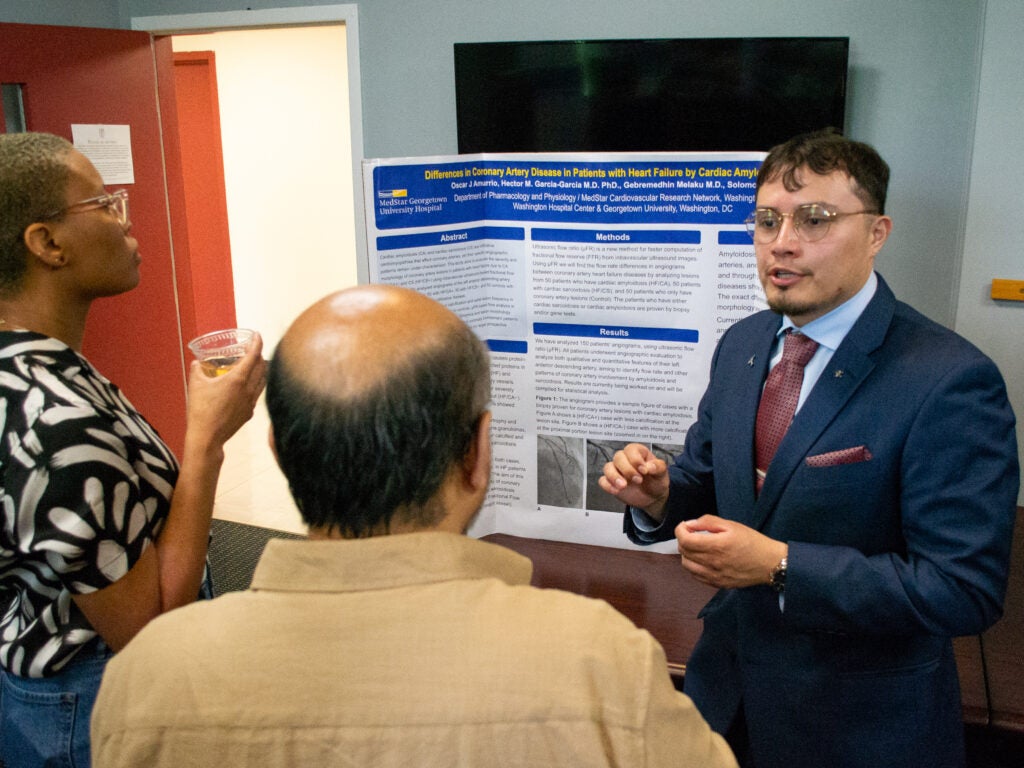 A student presents his research at the Pharmacology and Physiology poster session