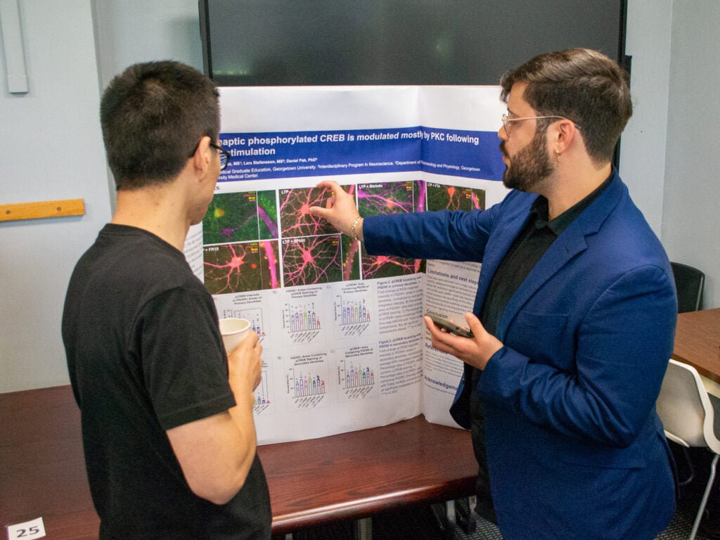 A student presents his research at the Pharmacology and Physiology poster session