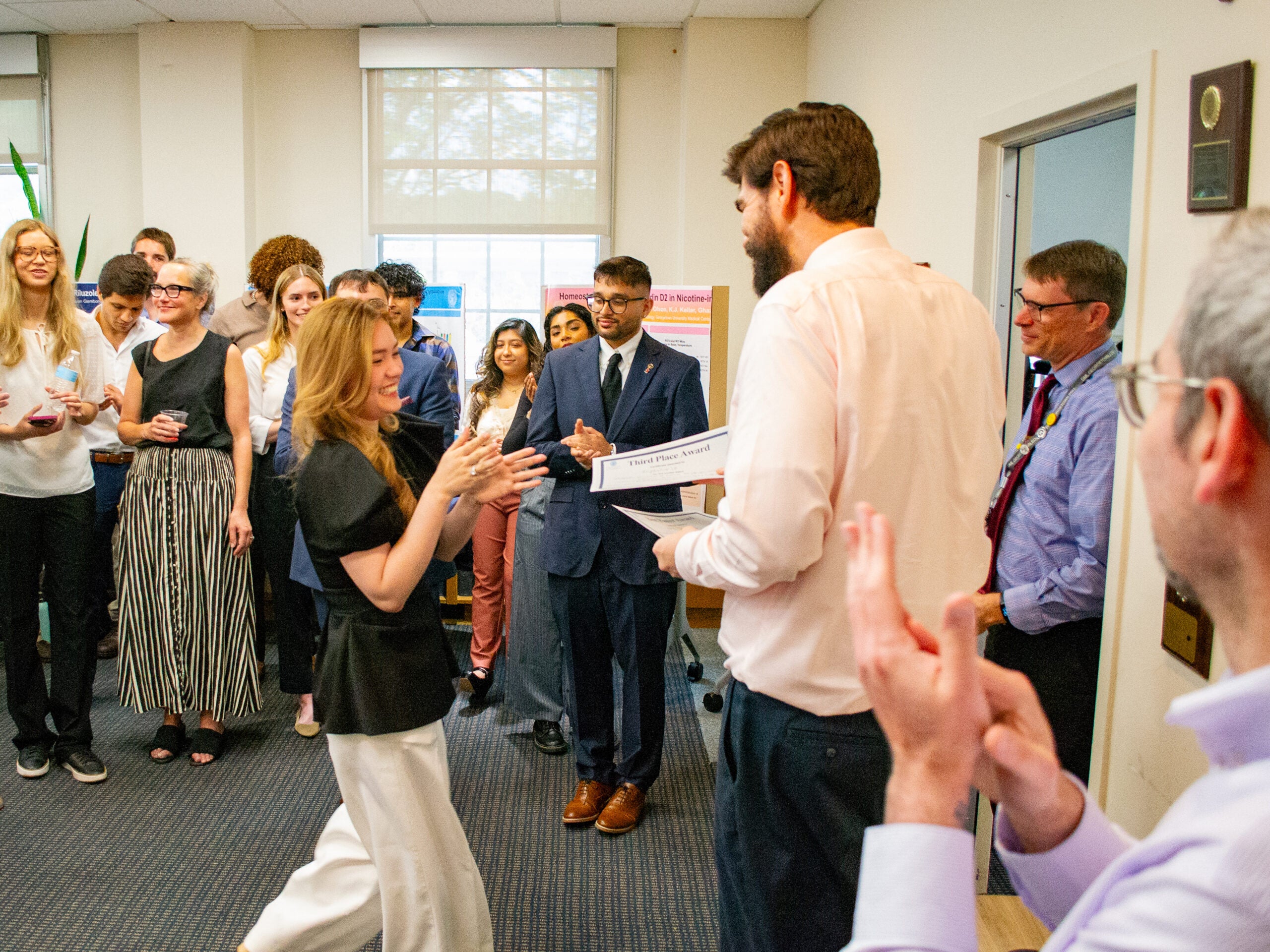 The third-place award winner accepts her award at the Pharmacology and Physiology poster session