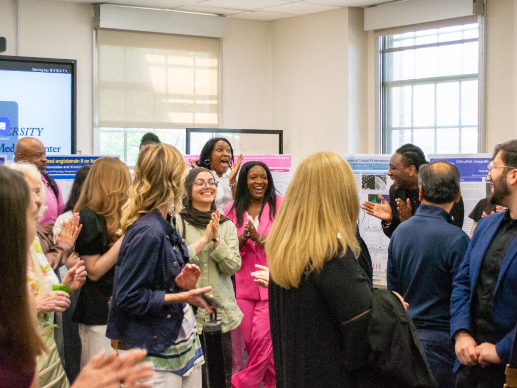 The first-place poster winner celebrates at the Pharmacology and Physiology poster session