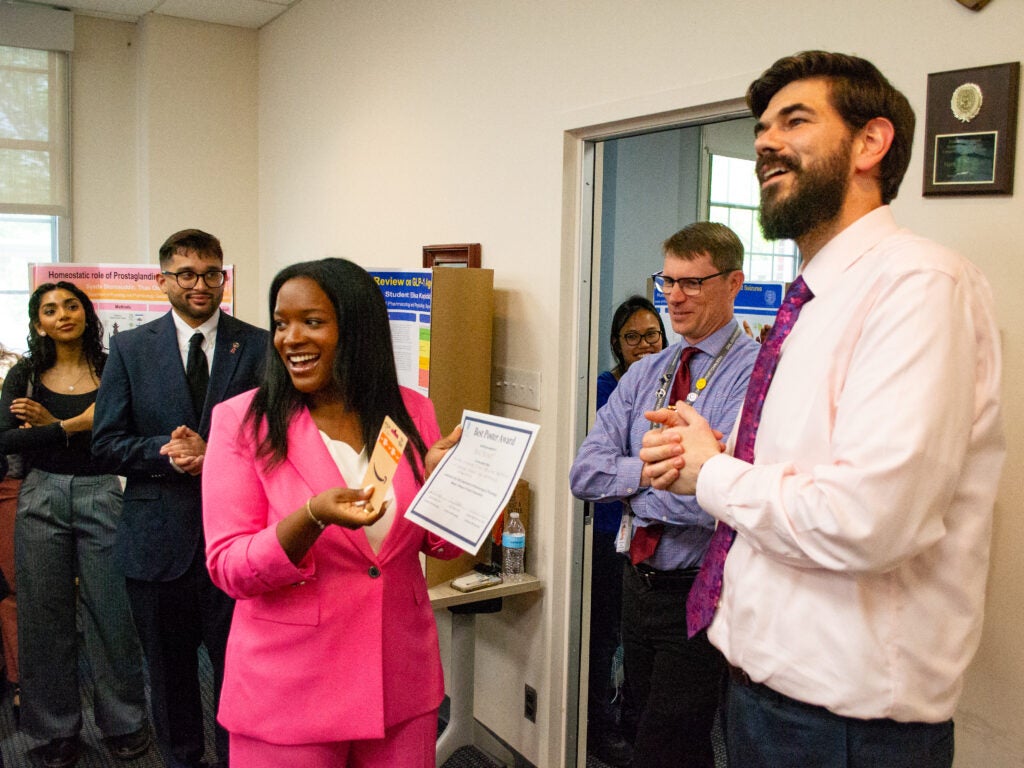 The first-place poster winner celebrates at the Pharmacology and Physiology poster session