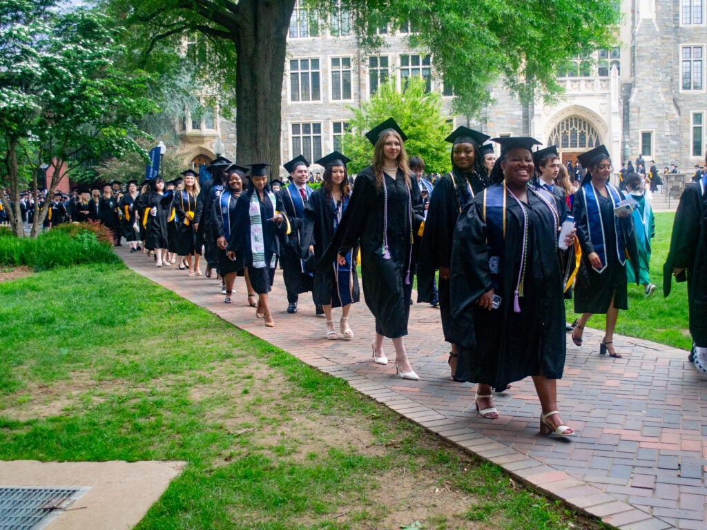 Integrative Medicine & Health Sciences graduates process across Copley Lawn at Commencement