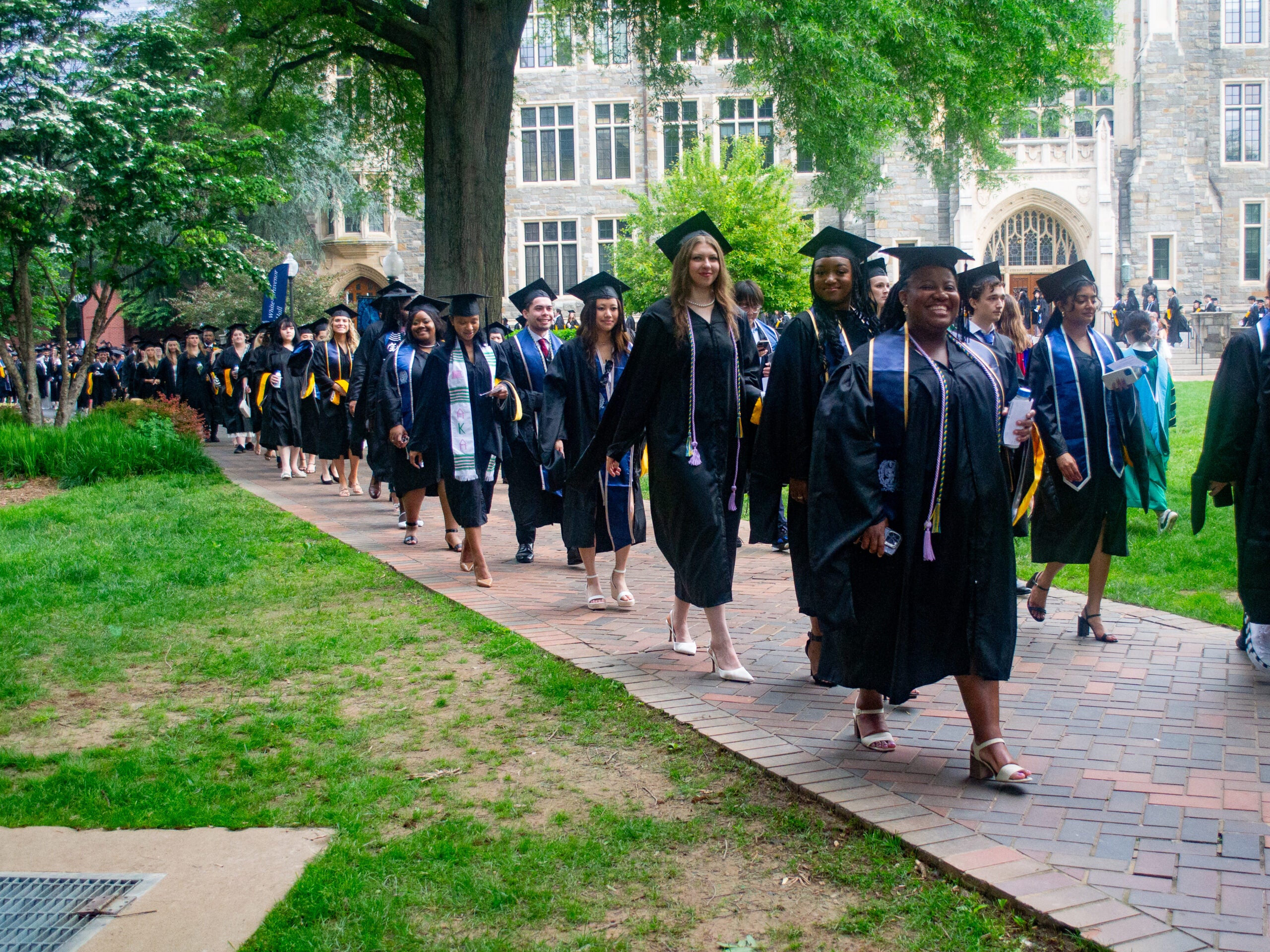 Integrative Medicine & Health Sciences graduates process across Copley Lawn at Commencement