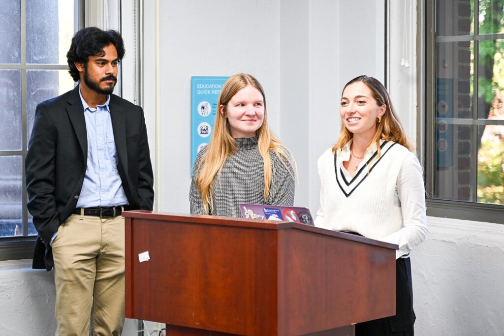 IPN Awards Committee Chair Mia Coutinho speaks as Senior Senator Rahul Gurram Thimugarri and former President Anna Pearson look on at the inaugural IPN Student Awards, October 2025