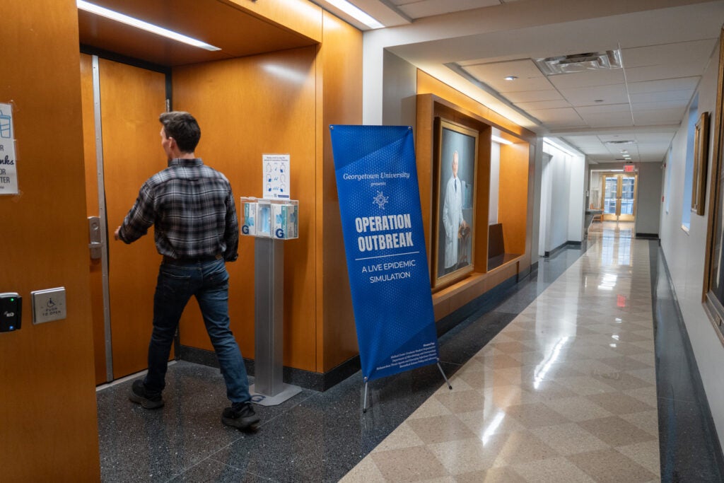 Operation Outbreak sign in the Medical Central building as a man walks through a doorway