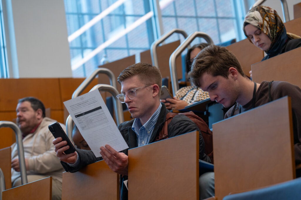 Participants check assignment sheets and their phones to see their roles