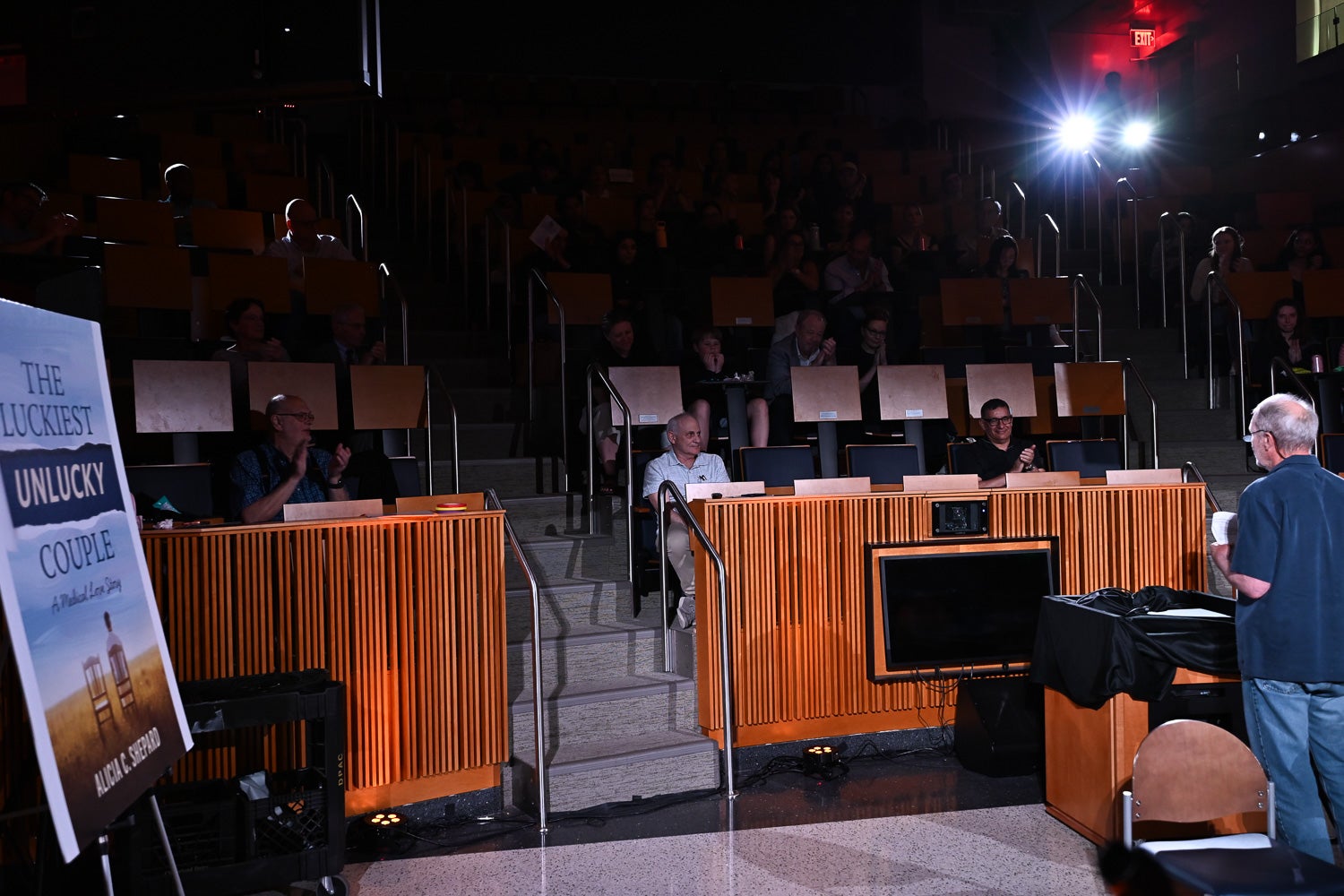 The audience applauds for oncologist Dr. Michael B. Atkins, seated in the front row, at the end of