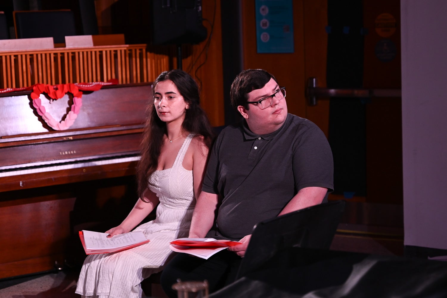 Undergraduate students Julia Small and Alexandros Georgussis sit on a bench while acting in