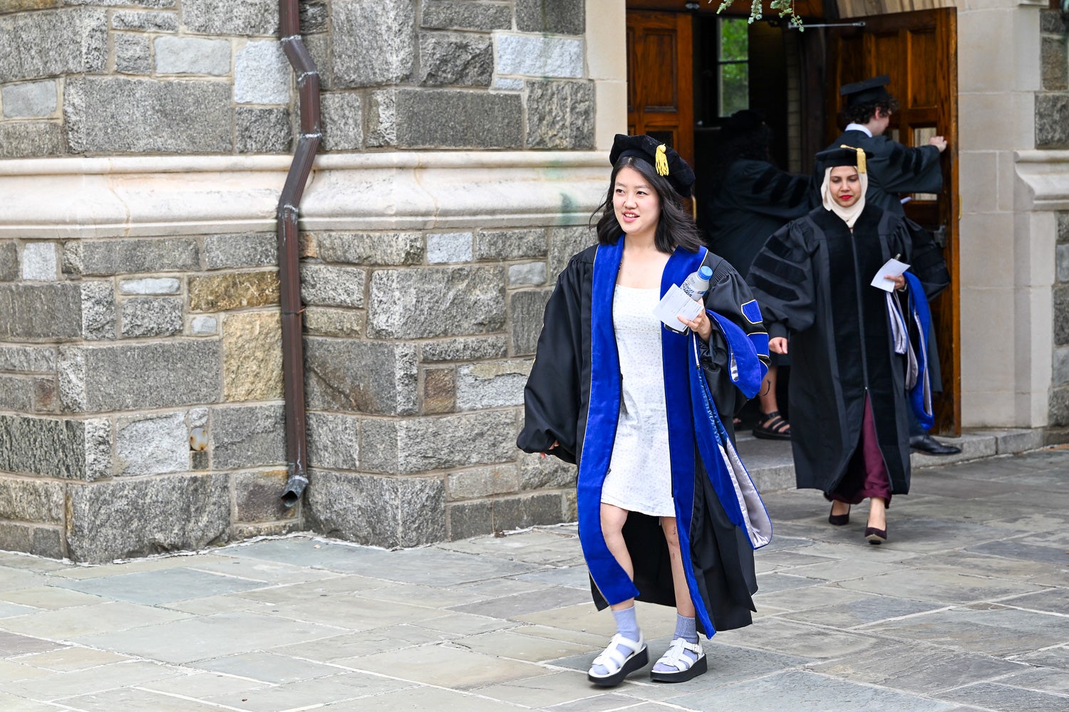 BGE Ph.D. graduates walk on White-Gravenor Esplanade before the School of Medicine Commencement ceremony