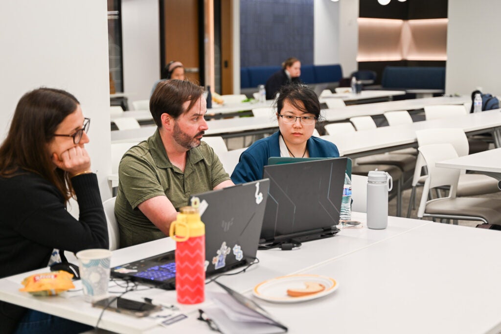 People work together on laptops at a table