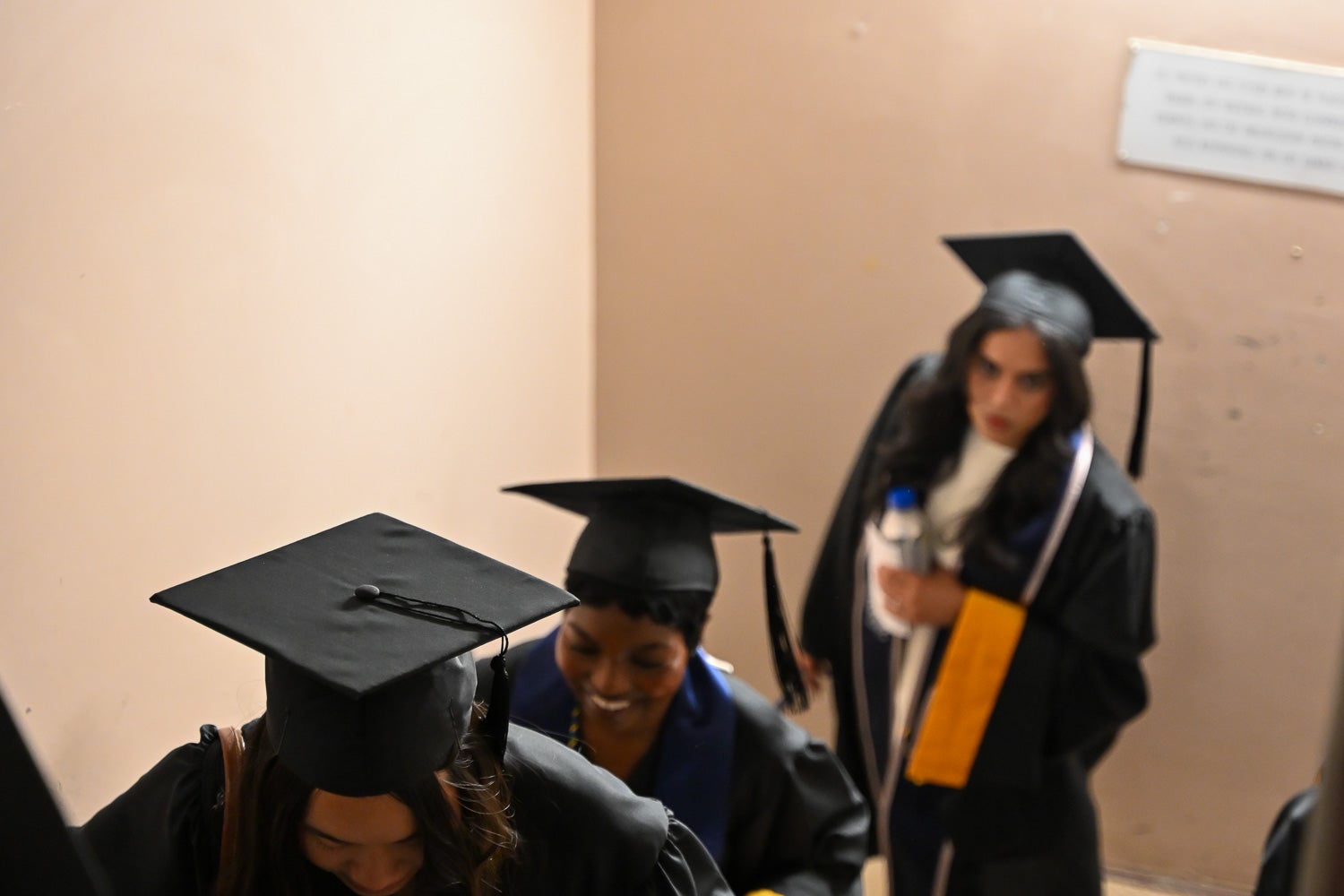 Graduates in commencement regalia climb the Intercultural Center stairs on their way to Red Square