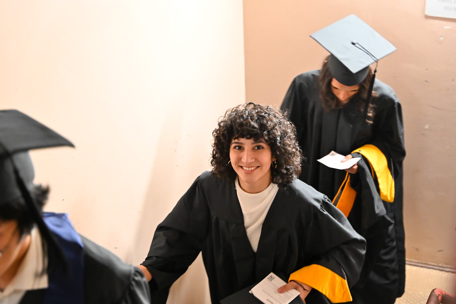 Graduates in commencement regalia climb the Intercultural Center stairs on their way to Red Square
