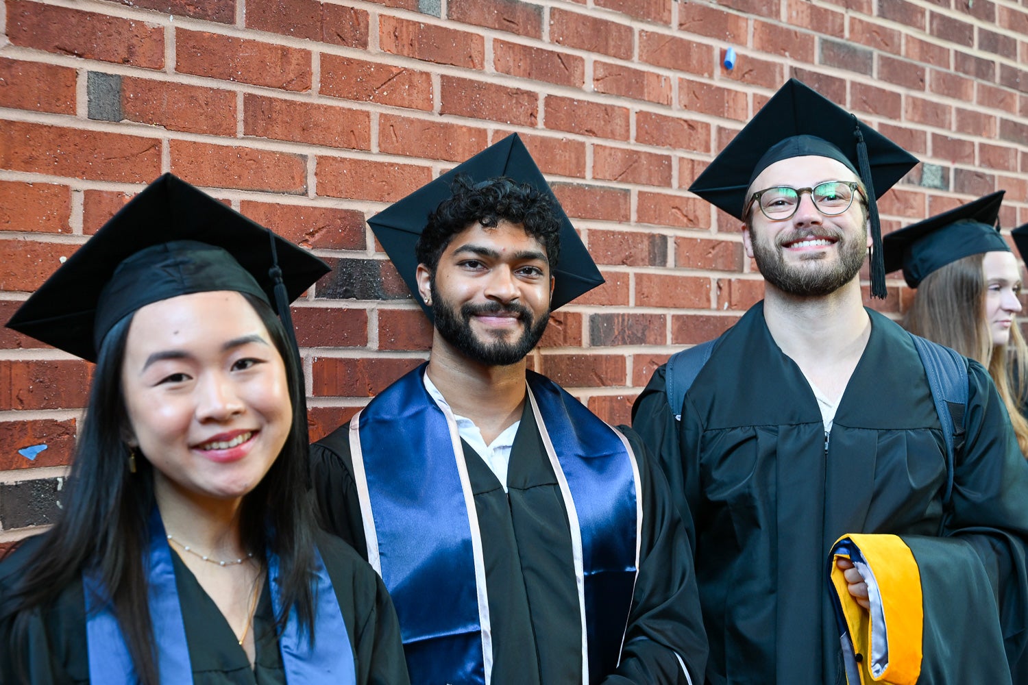 Graduates in commencement regalia pose together on Red Square before the ceremony