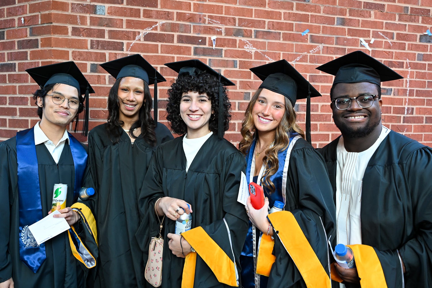 Graduates in commencement regalia pose together on Red Square before the ceremony