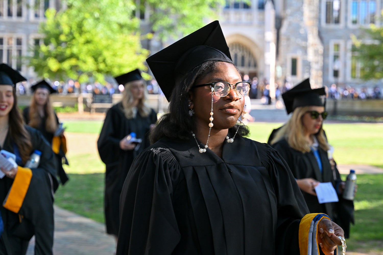 Graduates in commencement regalia process across Copley Lawn to the ceremony