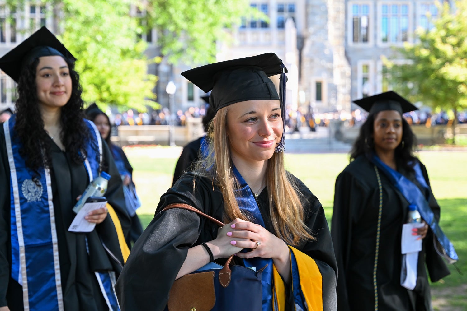 Graduates in commencement regalia process across Copley Lawn to the ceremony