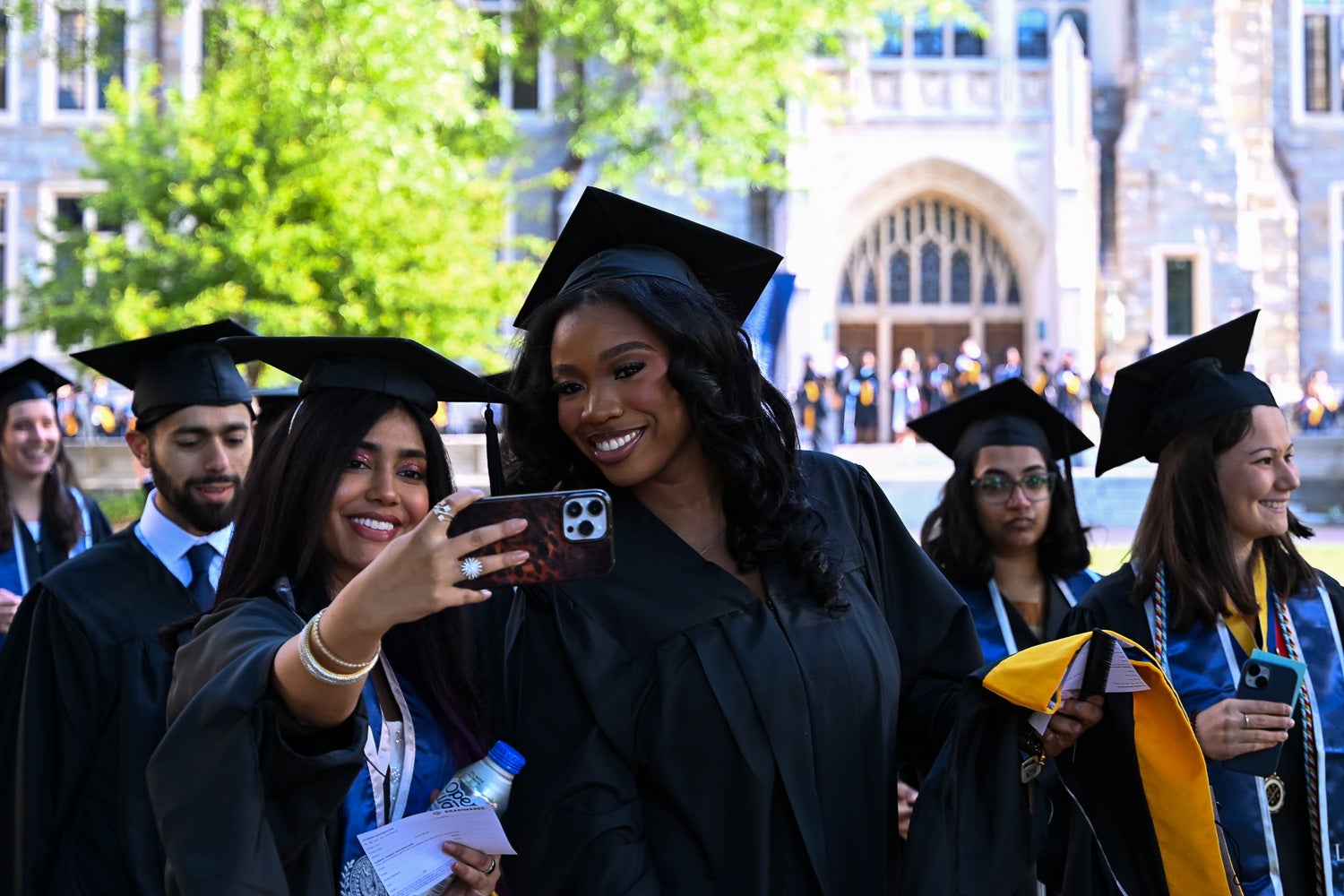 Graduates in commencement regalia process across Copley Lawn to the ceremony