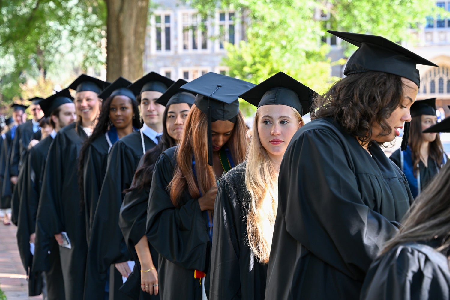 Graduates in commencement regalia process across Copley Lawn to the ceremony