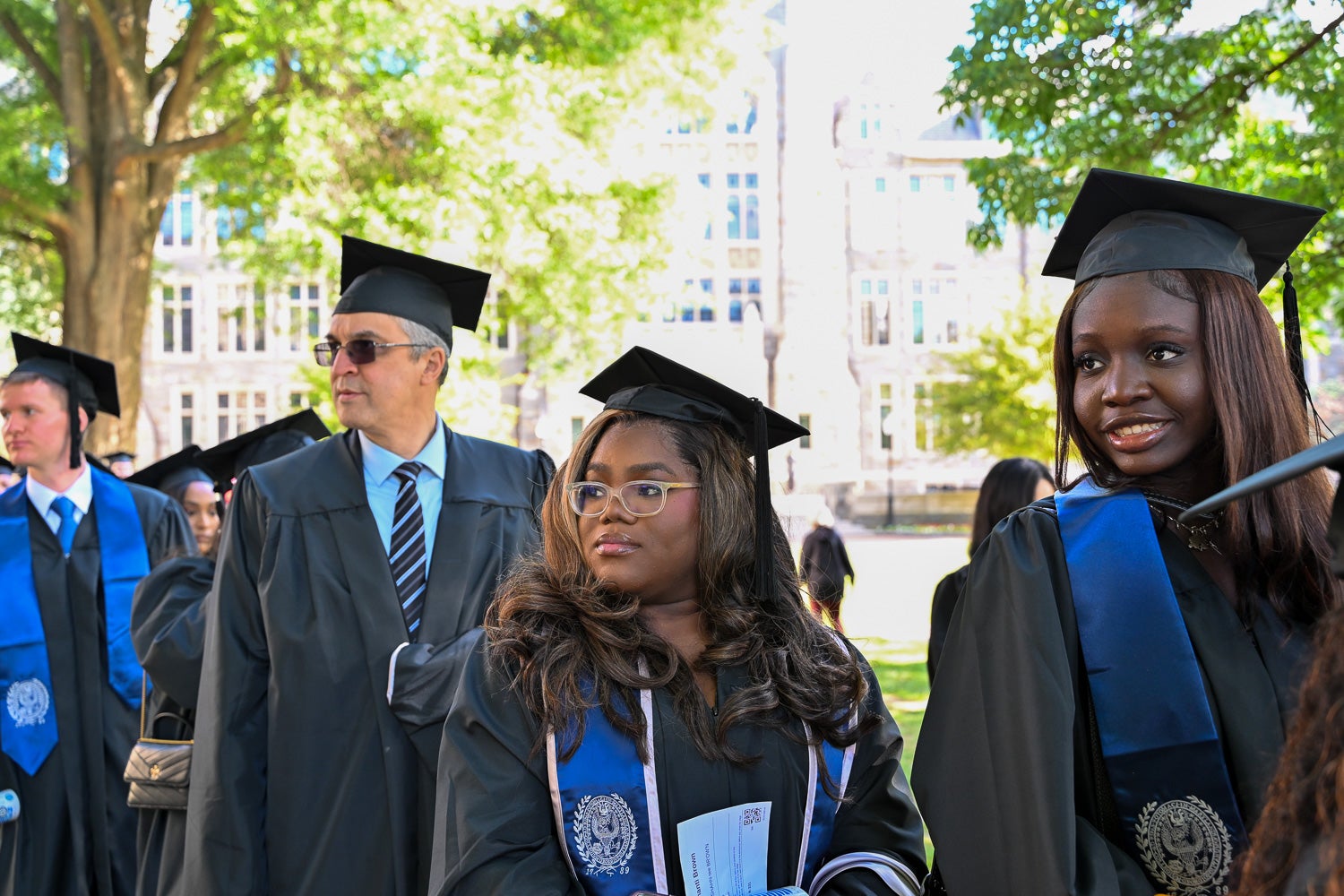 Graduates in commencement regalia process across Copley Lawn to the ceremony