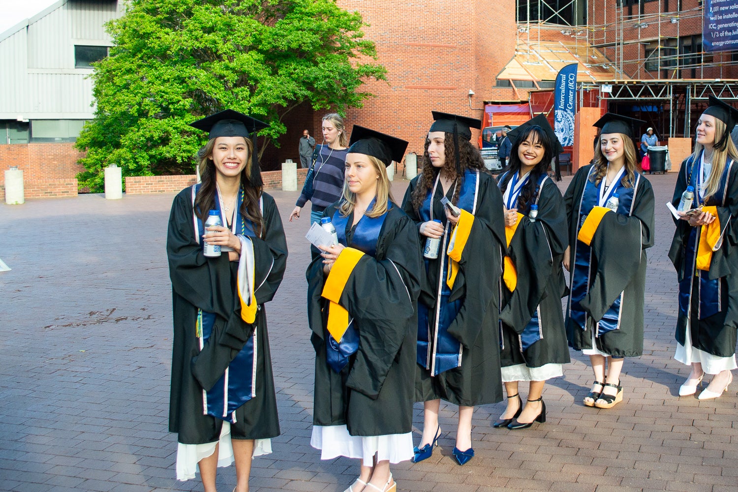 Graduates in commencement regalia stand together on Red Square before the ceremony