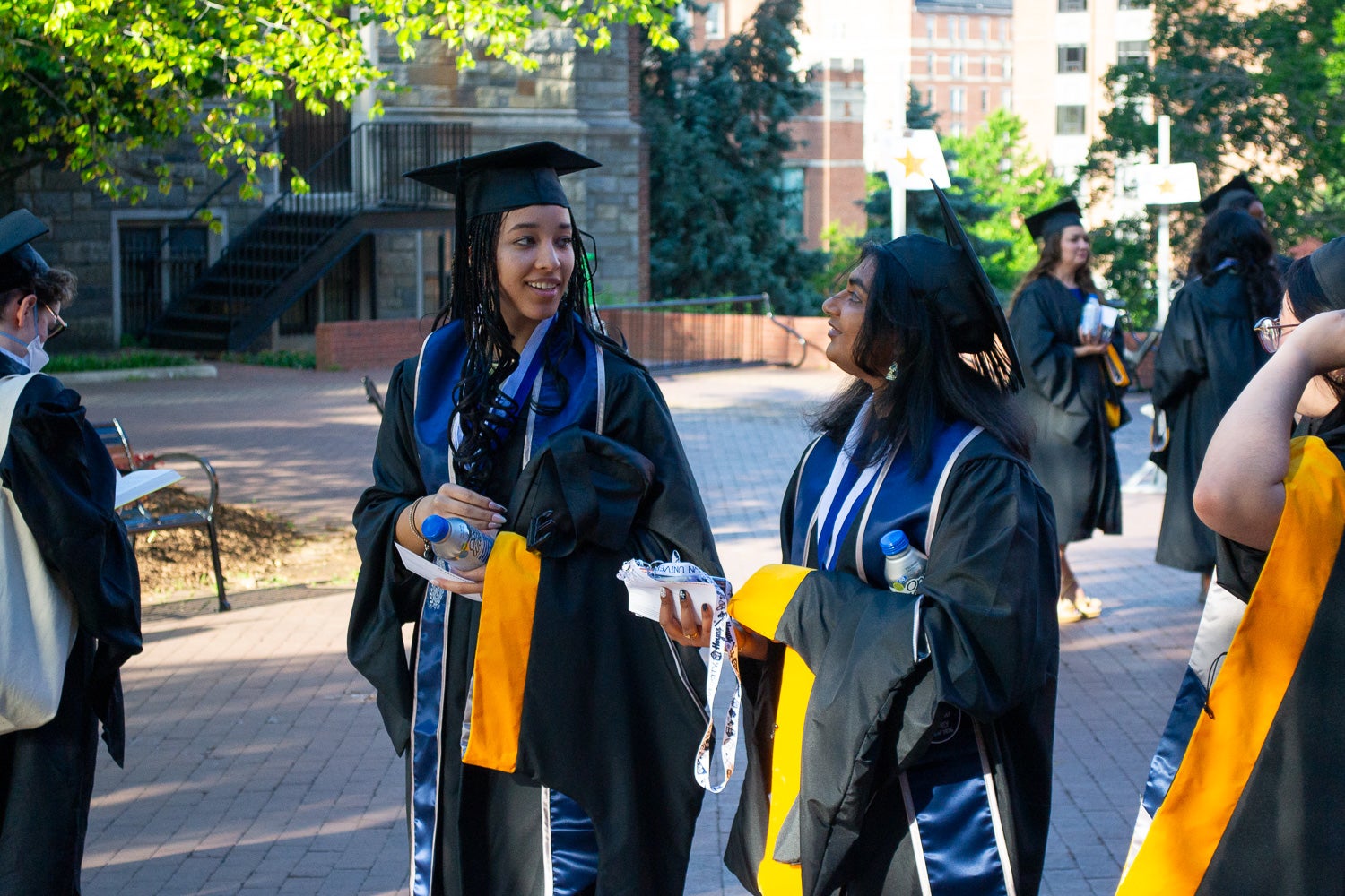 Graduates in commencement regalia stand together on Red Square before the ceremony