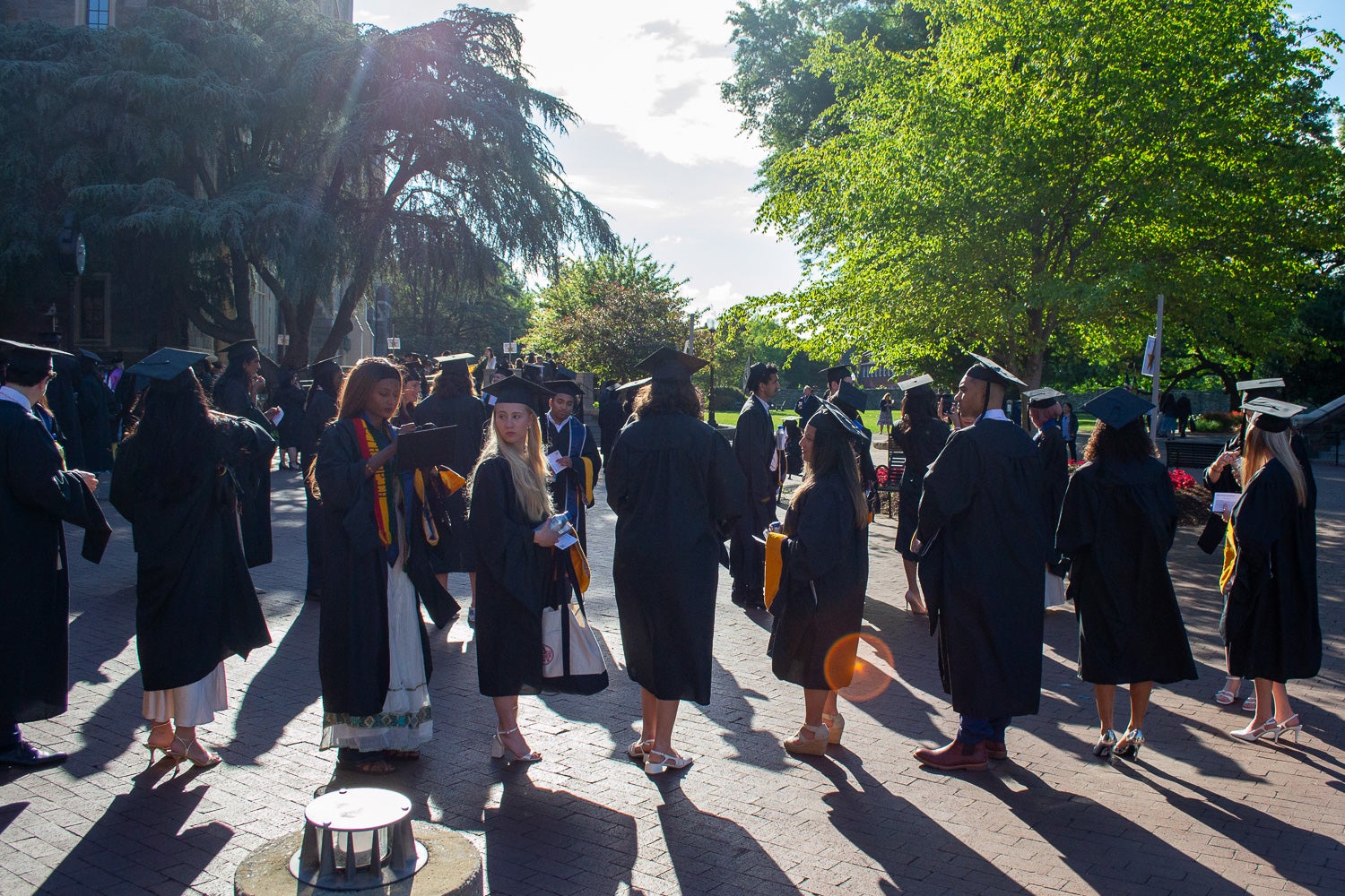 Graduates in commencement regalia stand together on Red Square before the ceremony