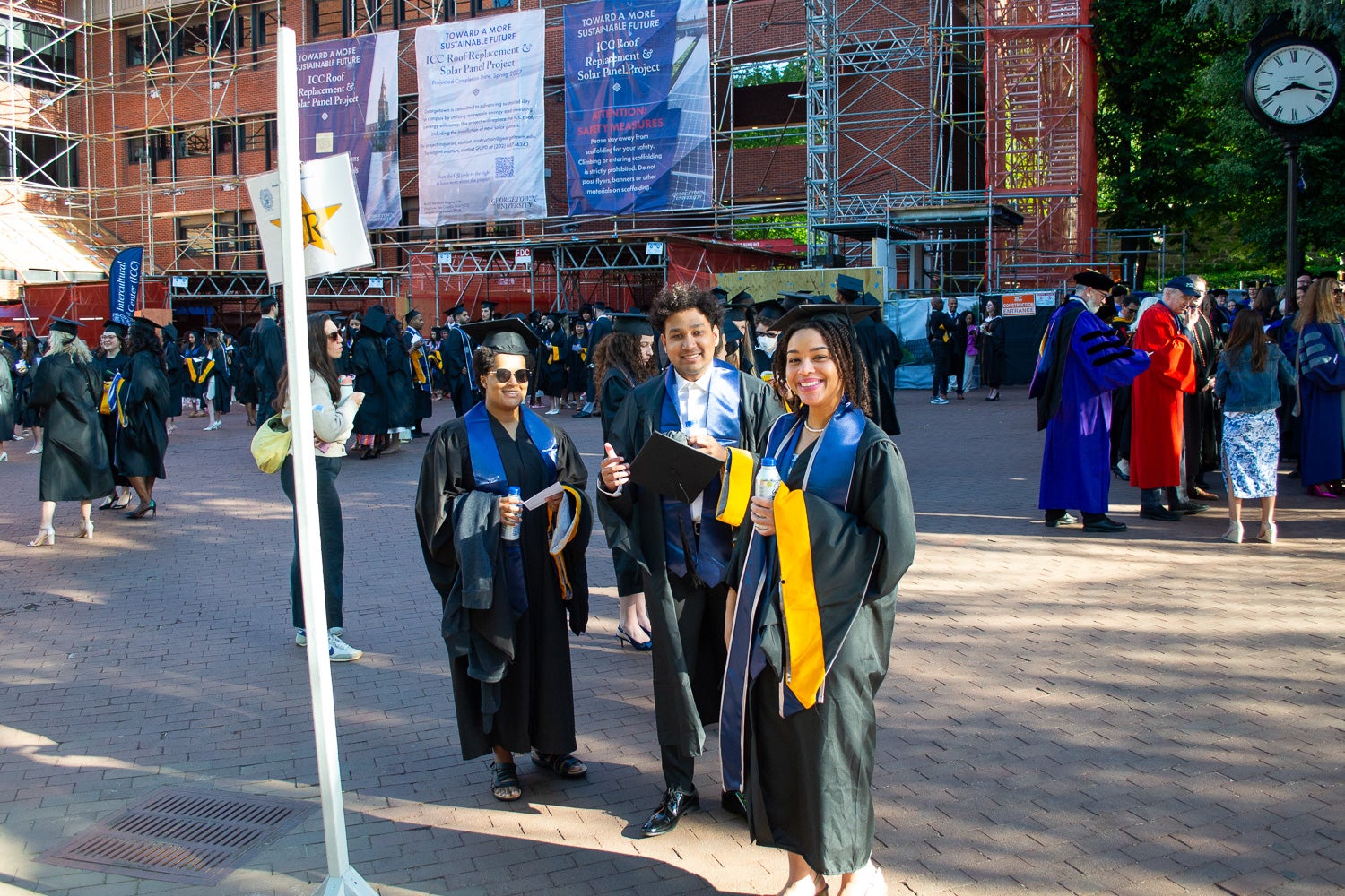 Graduates in commencement regalia stand together on Red Square before the ceremony