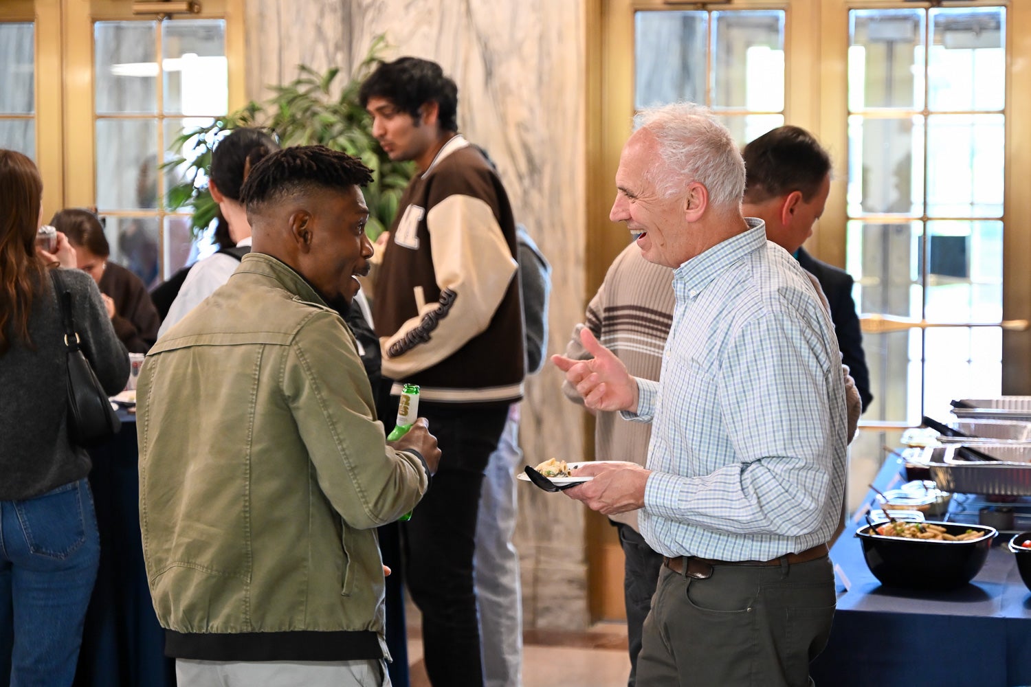 A student and professor talk at the Department of Microbiology & Immunology Reception