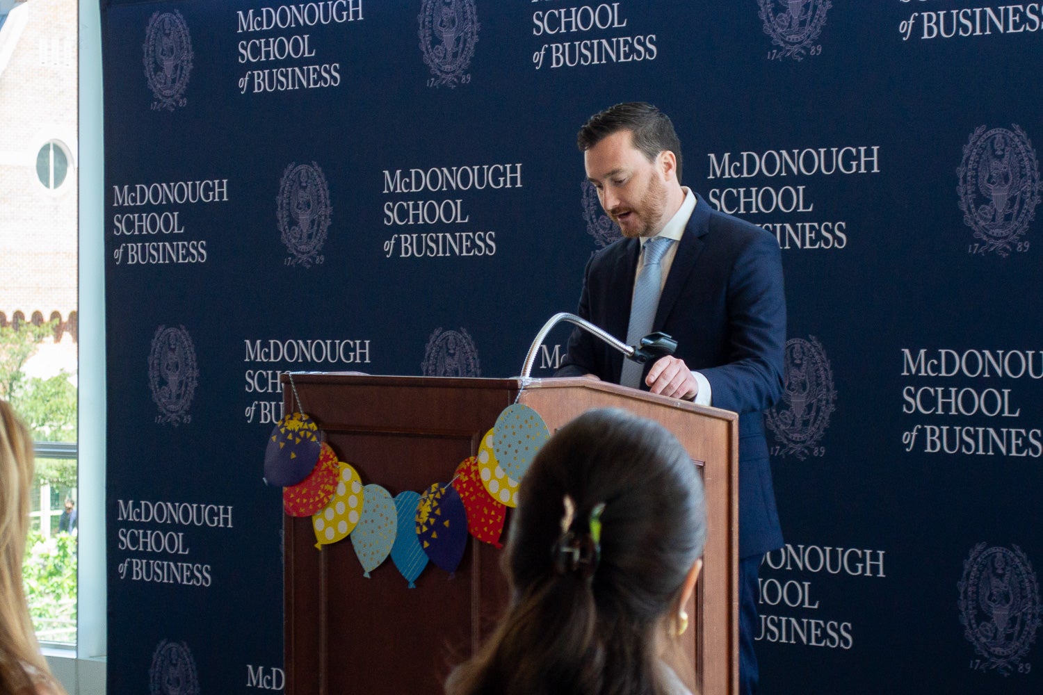 Bevan Main speaks at the podium at Neuroscience Student Research Day
