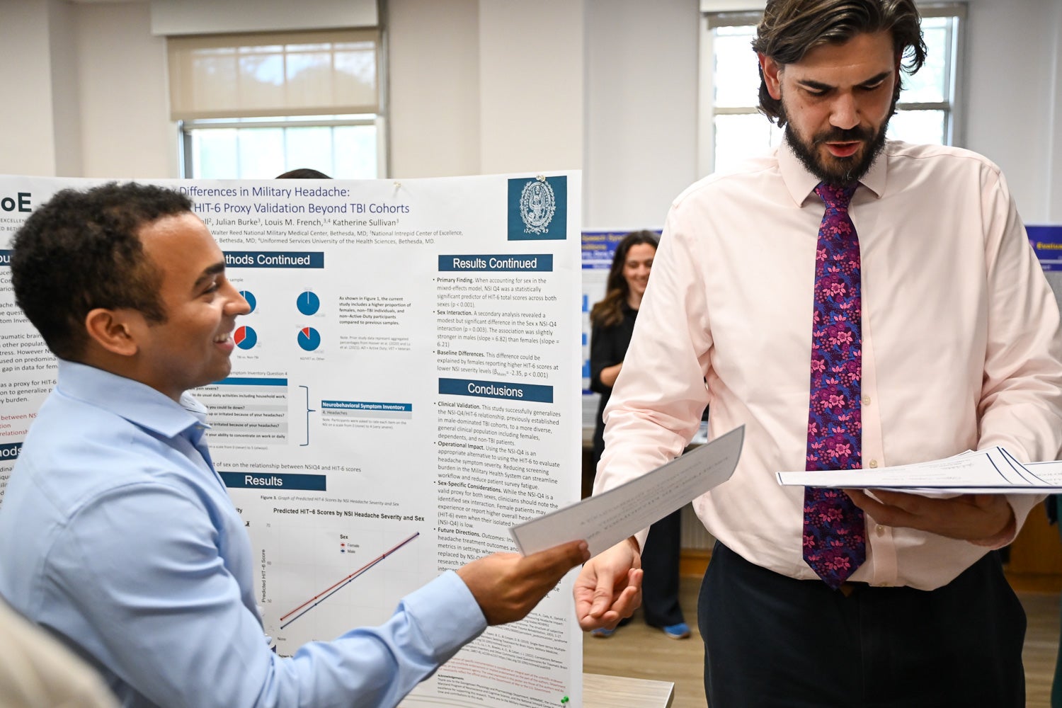 Josh Watson hands an award certificate to a student at Pharmacology & Physiology Poster Day