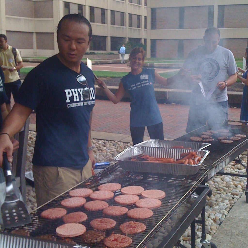SMP members cooking hamburgers at an event
