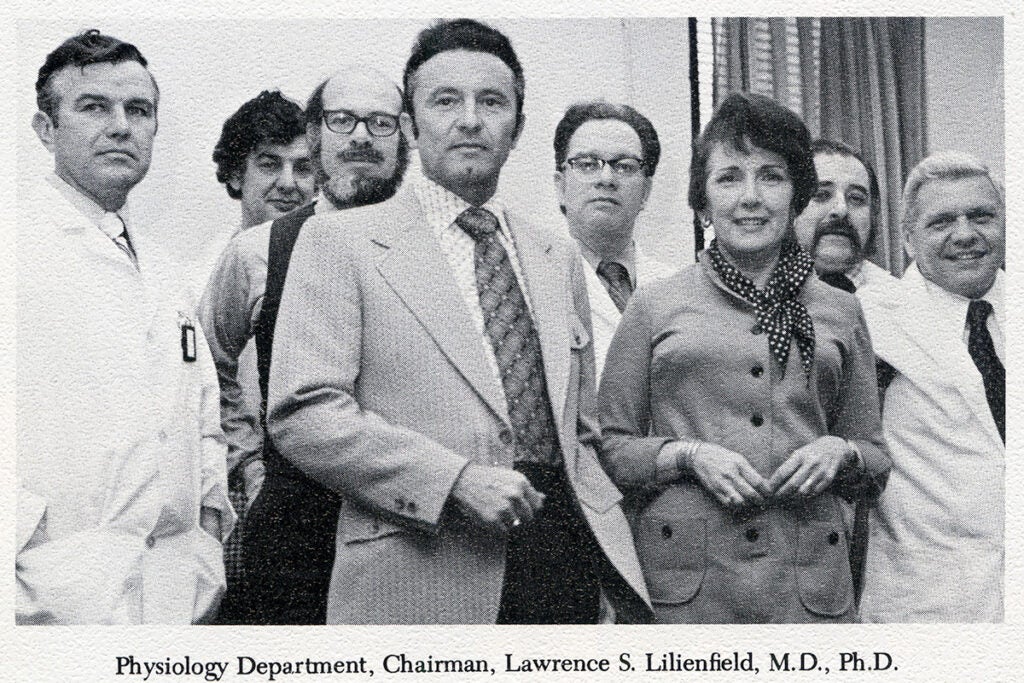 Faculty pose together in a black-and-white photograph labeled: "Physiology Department, Chairman, Lawrence S. Lilienfield, M.D., Ph.D."